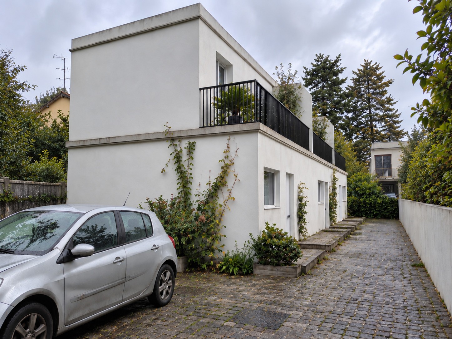 Visualisation d’une évolution du projet à Ris-Orangis, avec surélévation, façade claire, terrasse et cour pavée.