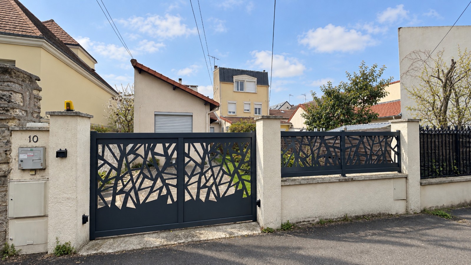 Maison à Colombes à l’état existant, avec volume bas sous toiture monopente et portail anthracite.