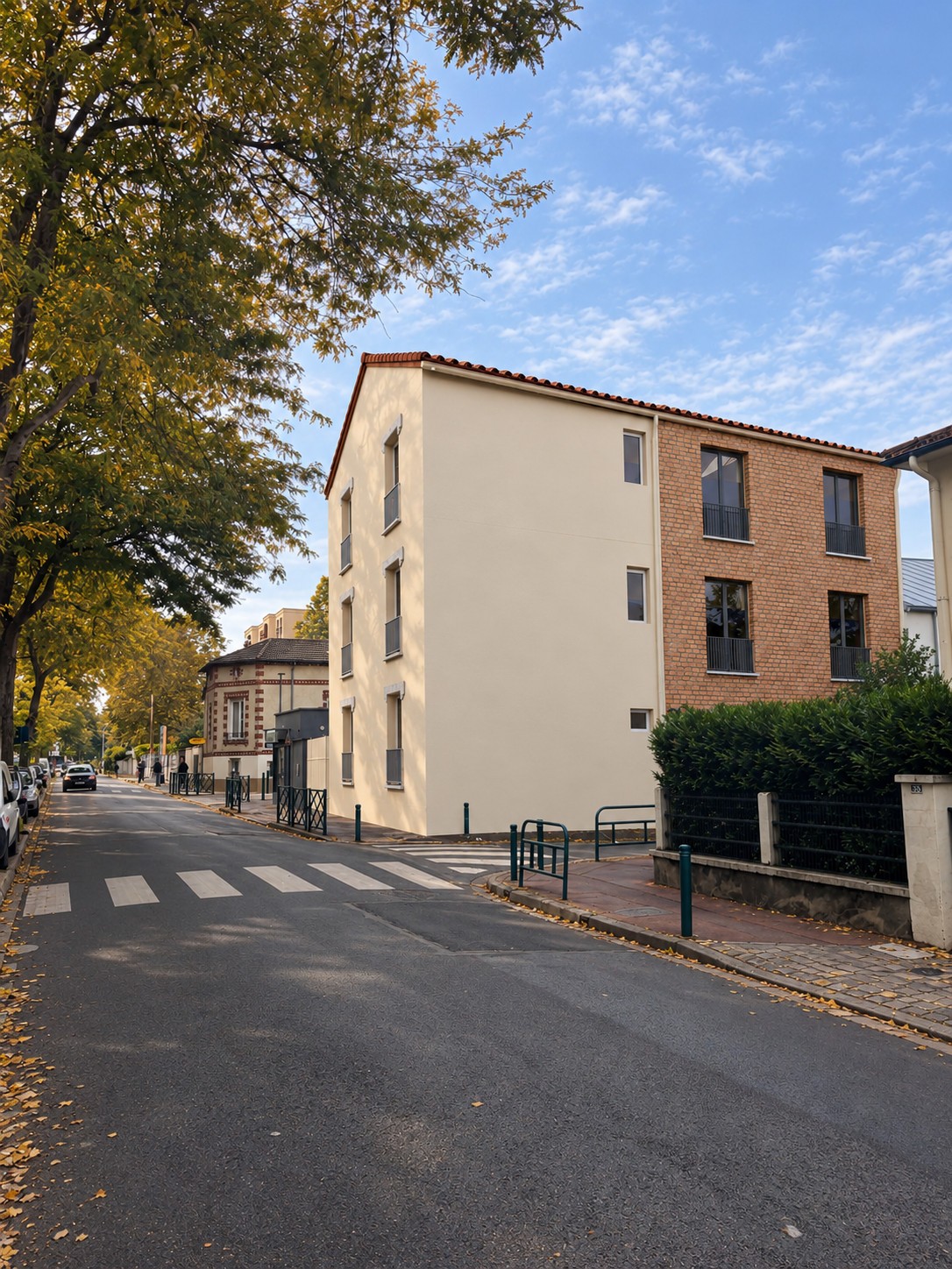 Projet de surélévation à Gennevilliers vu depuis l’angle de la rue, avec façades en enduit clair et en brique.